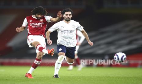 Mohamed Elneny dari Arsenal (kiri) menendang bola di depan pemain Manchester City Ilkay Gundogan selama pertandingan sepak bola Liga Utama Inggris antara Arsenal dan Manchester City di Stadion Emirates di London, Inggris, Minggu, 21 Februari 2021. 