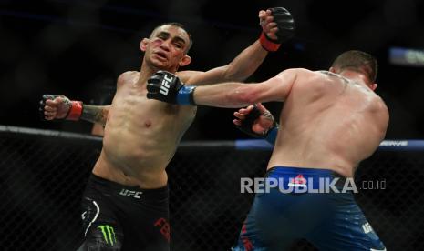 Tony Ferguson (kiri) melepas pukulan yang luput ke arah Gaethje (kanan) pada laga UFC 249 di  VyStar Veterans Memorial Arena,Florida, AS, Ahad (10/5). May 9, 2020; Jacksonville, Florida, USA; Tony Ferguson (red gloves) fights Justin Gaethje (blue gloves) during UFC 249 at VyStar Veterans Memorial Arena