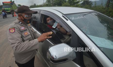 Petugas memeriksa kelengkapan dokumen pengendara yang akan masuk ke kota, di Jalan Bypass, Padang, Sumatera Barat, Selasa (13/7/2021). Pemkot Padang menerapkan penyekatan di enam titik pada masa PPKM Darurat mulai Selasa (13/7/2021) hingga (20/7/2021), bagi pengendara yang ingin masuk kota harus menunjukan kartu vaksin dan PCR H-2 atau Rapid Antigen H-1 kecuali angkutan logistik dan barang. 