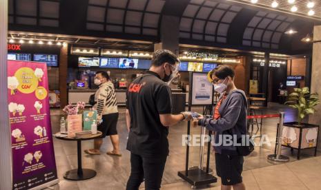 Pengunjung melakukan pemindaian kode batang melalui aplikasi Peduli Lindungi sebelum memasuki area Bioskop CGV 23 Paskal, Kota Bandung, Kamis (16/9). Pemerintah Kota Bandung kembali mengizinkan bioskop untuk beroperasi pada masa PPKM Level 3 dengan menerapkan protokol kesehatan secara ketat, seperti membatasi pengunjung menjadi 50 persen dari kapasitas, wajib melakukan skrining melalui aplikasi Peduli Lindungi, dilarang makan dan minum di area bioskop serta melarang pengunjung dengan usia di bawah 12 tahun untuk memasuki area bioskop. Foto: Republika/Abdan Syakura