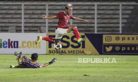 Pesepak bola Timnas U-22 Kushedya Hari Yudo (kanan) berebut bola dengan penjaga gawang Tira Persikabo Syahrul Trisna dalam laga uji coba di Stadion Madya, Senayan, Jakarta, Jumat (5/3).