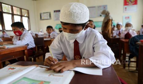 Siswa sekolah dasar mengikuti pelajaran memakai masker di Banda Aceh, Indonesia, 30 Mei 2022. Kegiatan belajar di sekolah umum sudah mulai normal kembali meski tetap menjalankan protokol kesehatan karena pemerintah Indonesia telah melonggarkan peraturan penggunaan wajah Masker di depan umum sebagai bagian dari kebijakan pelonggaran pembatasan setelah lebih dari dua tahun pandemi COVID-19.