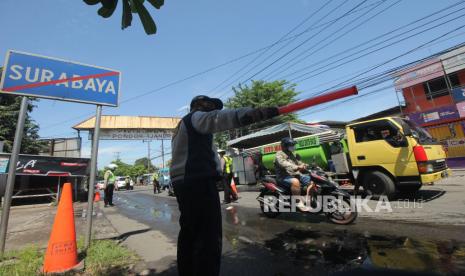 Petugas berjaga di Jalan Rungkut Menanggal, Surabaya, Jawa Timur, Ahad (26/4). Kegiatan Operasi Ketupat Semeru 2020 dengan mendirikan pos pemeriksaan (check point) di 17 lokasi akses masuk Surabaya itu dalam rangka pelarangan mudik dan mensosialisasikan aturan-aturan Pembatasan Sosial Berskala Besar (PSBB) di Surabaya. (ilustrasi)