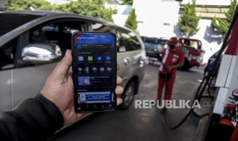 Pengendara kendaraan roda empat menunjukkan aplikasi MyPertamina saat membeli BBM subsidi jenis pertalite di SPBU Pertamina Riau, Jalan LLRE Martadinata, Kota Bandung, Jumat (1/7/2022). PT Pertamina (Persero) melalui anak usahanya PT Pertamina Patra Niaga melakukan uji coba pendaftaran serta pembelian BBM subsidi jenis pertalite dan solar menggunakan situs web atau aplikasi MyPertamina pada kendaraan roda empat di 11 daerah di lima provinsi mulai hari ini (1/7/2022). Foto: Republika/Abdan Syakura