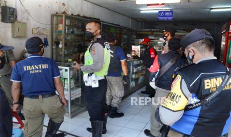 Bhabinkamtibmas bersama Satgas Covid-19 Regol, mendatangi toko yang masih buka dan tempat makan sekaligus mengingatkan warga agar mematuhi protokol kesehatan (Prokes) pencegahan Covid-19 saat sosialisasi pemberlakuan PPKM Darurat, di Jalan Otto Iskandardinata, Kota Bandung, Ahad (4/7). Pemerintah resmi memberlakukan Pembatasan Kegiatan Masyarakat (PPKM) Darurat mulai tanggal 3 hingga 20 Juli 202, di antaranya dengan menutup sementara tempat perbelanjaan dan tempat makan hanya melayani take away atau dibawa pulang. PPKM Darurat ini sebagai upaya memutus mata rantai penyebaran Covid-19.