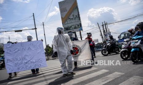 Sejumlah mahasiswa menggunakan baju hazmat dan jas almamater melakukan penggalangan dana untuk korban bencana alam banjir bandang di Cicurug Sukabumi di Buah Batu, Kota Bandung, Senin (28/9). Penggalangan dana oleh gabungan mahasiswa Bandung dan organisasi masyarakat Oi tersebut dilakukan untuk mengajak masyarakat ikut serta membantu korban bencana banjir bandang di Kabupaten Sukabumi. Foto: Abdan Syakura/Republika