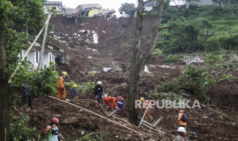 Recuers mencari korban longsor yang melanda sebuah desa di desa Cihanjuang, Jawa Barat, Indonesia, Selasa, 12 Januari 2021. Sejumlah orang tewas dan terluka dalam longsor yang dipicu oleh hujan deras pada hari Minggu di desa di Kabupaten Sumedang Jawa Barat. Beberapa korban merupakan penyelamat dari bencana longsor sebelumnya.