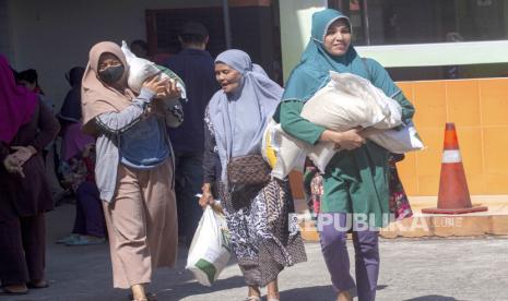 Warga membawa beras bantuan pangan cadangan pemerintah dalam penyaluran tahap kedua di Kantor Pos Batam Centre, Batam, Kepulauan Riau, Senin (6/11/2023).  Bantuan beras tersebut diberikan kepada 32.533 keluarga penerima manfaat (KPM) guna menekan kenaikan harga beras di pasaran sekaligus mengendalikan inflasi di daerah itu.  