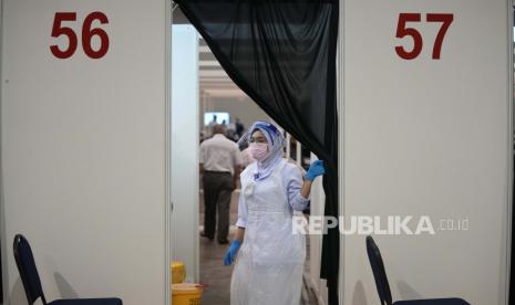  Seorang staf kesehatan melihat keluar dari sepatu bot vaksinasi untuk penyakit coronavirus (COVID-19) di pusat vaksinasi di Kuala Lumpur, Malaysia, Senin, 31 Mei 2021. 