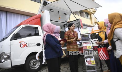 Kepala Eksekutif Pengawas Perilaku Pelaku Usaha Jasa Keuangan, Edukasi, dan Pelindungan Konsumen Otoritas Jasa Keuangan (OJK) Friderica Widyasari Dewi (tengah) berbincang dengan warga di samping Mobil SiMolek (Sarana Informasi Mobil Literasi dan Edukasi Keuangan) usai memberikan materi edukasi keuangan bagi pelaku UMKM dan ibu rumah tangga di Rusunawa Marunda, Jakarta Utara, Jumat (27/1/2023). Dalam kegiatan ini sejumlah pembicara dari OJK, BRI, Bank DKI dan PT Pegadaian menyampaikan sejumlah materi edukasi keuangan seperti perencanaan keuangan, waspada investasi dan pinjol ilegal serta materi Kredit Usaha Rakyat (KUR) dan Tabungan Emas. 