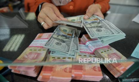 Petugas menghitung uang dollar AS di tempat penukaran valuta asing, (ilustrasi).  Rupiah menguat 67 poin atau 0,41 persen menuju Rp 16.133 per dolar AS.