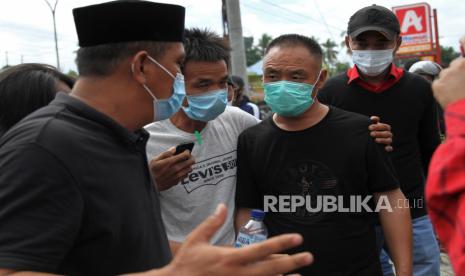 Mahasiswa memaksa turun dari kendaraan dua orang Tenaga Kerja Asing asal China di pintu Bandara Udara Haluoleo di jalan Wolter Mongonsidi Kecamatan Ranomeeto, Konawe Selatan, Sulawesi Tenggara, Selasa (23/6/2020). Ratusan mahasiswa yang tergabung dar beberapa elemen tersebut menolak kedatangan 500 orang Tenaga Kerja Asing (TKA) asal China yang dipekerjakan di salah satu perusahaan pertambangan di Kabupaten Konawe, Sulawesi Tenggara. ANTARA FOTO/Jojon/hp.  