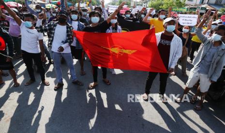 Pemerintah Bayangan Myanmar Pamerkan Pasukan Bersenjata Baru. Para pengunjuk rasa memberi hormat tiga jari saat mereka membawa bendera serikat mahasiswa selama protes terhadap kudeta militer di Mandalay, Myanmar, 21 Mei 2021.