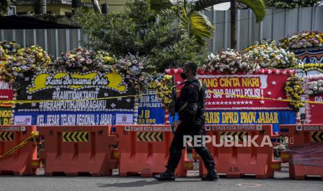 Anggota kepolisian berjalan di depan deretan karangan bunga pascaledakan bom bunuh diri di Mapolsek Astana Anyar, Jalan Astana Anyar, Kota Bandung, Jumat (9/12/2022). Karangan bunga tersebut sebagai bentuk penghargaan dan dukungan untuk Polri dalam memberantas terorisme, serta ucapan duka cita atas wafatnya Aiptu Anumerta Sofyan dalam peristiwa ledakan bom bunuh diri tersebut. Republika/Abdan Syakura