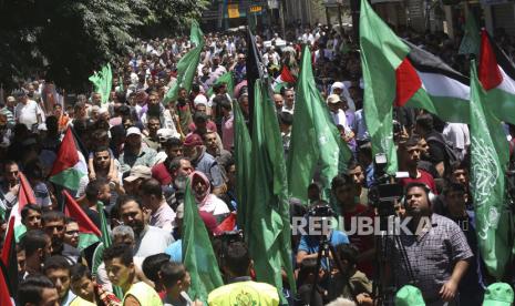  Pendukung Hamas mengibarkan bendera hijau dan nasional mereka selama protes terhadap rencana Israel untuk mencaplok bagian-bagian Tepi Barat dan inisiatif Timur Tengah Presiden AS Donald Trump, setelah salat Jumat di jalan utama Kota Khan Younis, Jalur Gaza, Jumat, 26 Juni 2020 .