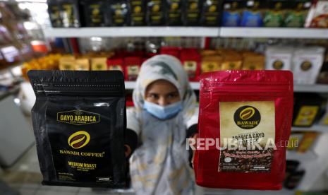 Pekerja menunjukan bubuk kopi arabika gayo yang telah dikemas dengan bungkusan hasil kerajinan Usaha Mikro, Kecil dan Menengah (UMKM) rumah tangga dan Industri Kecil Menengah (IKM) di bazar UMK-IKM dan pasar murah Asia Mart Center, Banda Aceh, Aceh, Selasa (19/1/2021). Pemasaran secara mandiri, media sosial dan keterlibatan pihak swasta dengan menggelar bazar atau pasar murah diharapkan dapat membangkitkan kembali perekonomian di tengah pandemi COVID-19. 