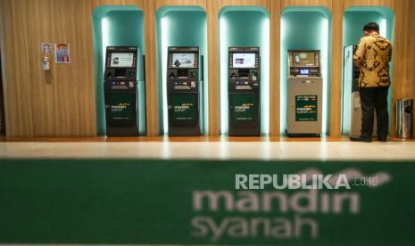 Nasabah mengambil uang di ATM Bank Syariah Mandiri, Jakarta, Rabu (14/10/2020). Pemerintah resmi melakukan merger pada tiga bank syariah BUMN yaitu PT Bank Syariah Mandiri (BSM), PT Bank BNI Syariah dan PT Bank BRI Syariah Tbk dengan tujuan agar Indonesia yang merupakan negara mayoritas umat muslim mampu memiliki bank syariah terbesar di tanah air yang berskala global. 