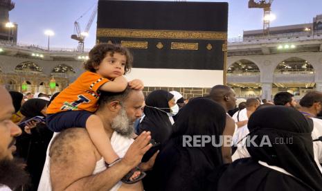  Seorang jamaah haji menggendong putranya saat dia mengelilingi Kabah di Masjidil Haram, di kota suci Mekah, Arab Saudi, Selasa, 5 Juli 2022. Arab Saudi diperkirakan akan menerima satu juta Muslim untuk menghadiri ibadah haji , yang akan dimulai pada 7 Juli, setelah dua tahun membatasi jumlahnya karena pandemi virus corona.