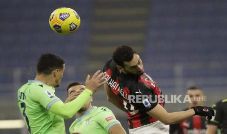 AC Milan Hakan Calhanoglu, kanan, melompat untuk bola dengan Lazio Luiz Felipe, kiri, saat pertandingan sepak bola Serie A antara AC Milan dan Lazio, di stadion San Siro di Milan, Italia, Rabu, 23 Desember 2020. 