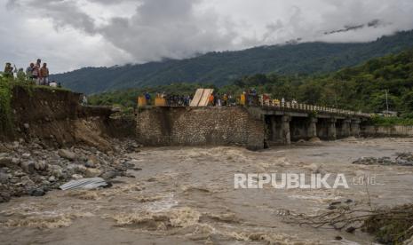 Warga menyaksikan jembatan yang putus akibat tergerus banjir di Desa Pakuli, Gumbasa, Sigi, Sulawesi Tengah, Selasa (6/9/2022). (Ilustrasi)