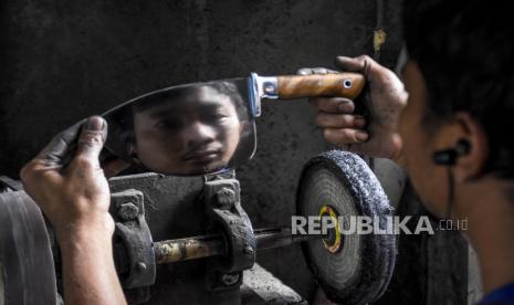 Perajin menyelesaikan pembuatan pisau berbahan baku baja di rumah produksi Pisau Krakatau, Cibabat, Cimahi Utara, Kota Cimahi, Jumat (2/10). Berbagai macam jenis pisau modern dan tradisional yang dijual dengan harga Rp500 ribu sampai Rp5 juta per pisau tergantung ukuran dan tingkat kesulitan tersebut telah menembus pasar ekspor di Amerika Serikat, Italia, Spanyol, Kanada dan Malaysia serta dijual ke berbagai kota di Indonesia. Krakatau Steel mencatat industri baja global mulai menunjukkan pemulihan yang mana produksi baja mentah di Asia juga telah meningkat sejak terjadi penurunan pada Arpil. 