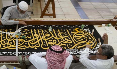  Amir Makkah Serahkan Kiswah Kepada Penjaga Ka'bah. Foto:  Pekerja Saudi menyulam kaligrafi Islam menggunakan benang perak murni atau benang perak berlapis emas selama tahap akhir dalam persiapan tirai, atau Kiswah, yang menutupi Kabah, struktur berbentuk kubus di jantung Masjidil Haram, di Kiswah pabrik di Mekah, Arab Saudi, Rabu, 6 Juli 2022. Jemaah haji berkumpul di kota suci Mekah di Arab Saudi untuk haji terbesar sejak pandemi virus corona sangat membatasi akses ke salah satu dari lima rukun Islam.