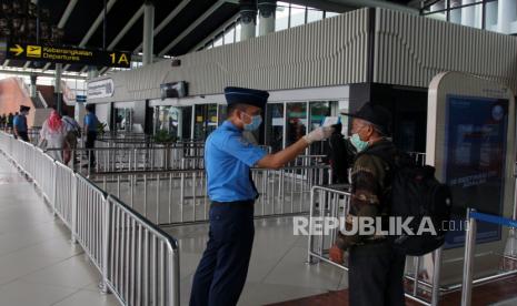 58 Jamaah Umroh akan Diperiksa di Bandara Soekarno-Hatta. Foto ilustrasi petugas melakukan pengecekan suhu tubuh calon penumpang di Terminal 1 A Bandara Soekarno Hatta, Tangerang, Banten, Jumat (27/3/2020). Menurut data dari Kementerian Perhubungan wabah epidemi COVID-19 menurunkan tingkat okupansi transportasi massal di seluruh Indonesia seperti pesawat