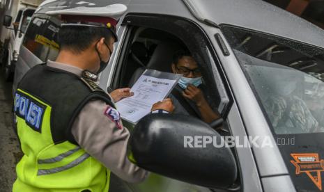 Petugas Kepolisian memeriksa dokumen pengendara yang melintas di check point penyekatan arus mudik Gerbang Tol Cikupa, Tangerang, Banten, Kamis (6/5/2021). Petugas gabungan memberlakukan penyekatan pemudik jelang perayaan Hari Raya Idul Fitri 1442 H guna mengantisipasi risiko peningkatan kasus penularan COVID-19. 