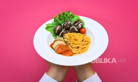 Pekerja menunjukkan salah satu menu makanan sehat.