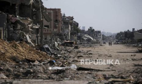 Pengungsi Palestina berjalan di samping bangunan yang hancur di Khan Younis, Jalur Gaza Selatan, Rabu (5/6/2024). Menurut Kementerian Kesehatan Palestina dan Pasukan Pertahanan Israel (IDF), sejak militan Hamas melancarkan serangan terhadap Israel dari Jalur Gaza pada 07 Oktober 2023, dan operasi Israel di Gaza dan Tepi Barat  tercatat Lebih dari 36.000 warga Palestina dan lebih dari 1.400 warga Israel terbunuh. EPA-EFE/MOHAMMED SABER