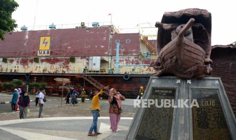 Pengunjung menyaksikan monumen kapal dan situs tsunami PLTD Apung di Desa Punge, Blancut, Banda Aceh, Aceh, Sabtu (1/8/2020). Sejak hari pertama liburan Idul Adha 1441 Hijriah, situs tsunami PLTD Apung yang baru selesai direnovasi itu mulai ramai pengunjung, namun pemerintah setempat membatasi jumlah pengunjung dan memperketat protokol kesehatan dengan menerapkan wajib masker, pengecekan suhu badan,  dan cuci tangan guna mencegah penyebaran COVID-19. 