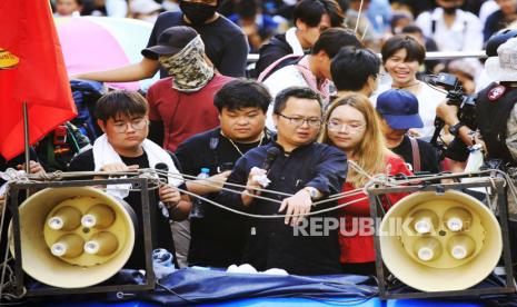 Pengacara hak asasi manusia Thailand Anon Numpa (depan C), diapit oleh juru bicara Persatuan Mahasiswa Thailand Panusaya Rung Sithijirawattanakul (depan R) dan aktivis Pro-demokrasi Parit Penguin Chiwarak (depan L) menonton bersama aktivis lain dari truk selama protes anti-pemerintah di Bangkok, Thailand, 14 Oktober 2020. Pengunjuk rasa pro-demokrasi ambil bagian dalam unjuk rasa melawan elit kerajaan dan pemerintah yang didukung militer menyerukan pengunduran diri Perdana Menteri Thailand Prayut Chan-o-cha, penulisan ulang piagam baru dan monarki direformasi berada di bawah konstitusi.