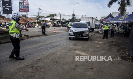 Petugas kepolisian memeriksa kendaraan yang hendak masuk tol melalui Pintu Gerbang Tol Padalarang, Kabupaten Bandung Barat, Kamis (28/5). Penyekatan tersebut dilakukan untuk menghalau pemudik dari kampung halaman untuk tidak kembali ke kota sebelumnya guna mengantisipasi lonjakan penyebaran kasus Covid-19