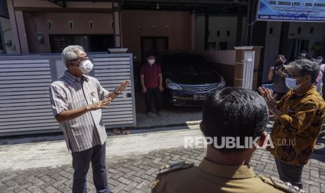 Gubernur Jawa Tengah Ganjar Pranowo (kiri) menyapa warga orang tanpa gejala (OTG) COVID-19 dengan jarak jauh di Kabupaten Batang, Jawa Tengah, Selasa (29/6/2021). Dalam kesempatan itu, Gubernur Jateng Ganjar Pranowo menyampaikan kepada warga sekitar di lokasi warga yang terpapar positif COVID-19 untuk lebih memperkuat program 