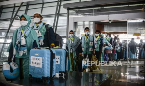 Sejumlah calon jamaah umrah mengantre untuk memasuki Terminal 3 Bandara Internasional Soekarno-Hatta, Tangerang, Banten, Sabtu (8/1). Sebanyak 419 orang berangkat melaksanakan ibadah umrah setelah beberapa tahun terakhir Indonesia tidak mengirimkan jamaah akibat pandemi Covid-19. Bantah Umroh Dihentikan, Menag: Yang Dihapus Kebijakan Satu Pintu