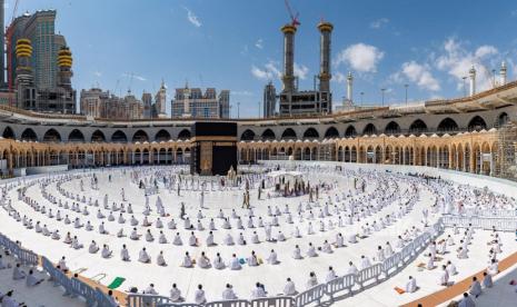  Umat Muslim, yang menjaga jarak, melakukan sholat Jumat saat mereka tiba untuk menunaikan Umrah, di Masjidil Haram, di kota suci Mekkah, Arab Saudi, 26 Februari 2021.