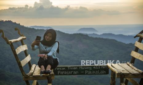 Pengunjung memotret dengan gawainya di wisata puncak Titian Musang di desa Patikalain, Kabupaten Hulu Sungai Tengah, Kalimantan Selatan, Jumat (15/10/2021). Wisata alam yang dikelola oleh Pokdarwis Datar Bunglai tersebut selain menawarkan keindahan bentangan alam Pegunungan Meratus itu juga difungsikan sebagai pusat edukasi dan konservasi alam. 