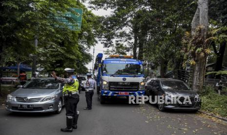 Petugas gabungan mengatur lalu lintas saat Operasi Parkir Liar di Jalan Ganesa, Coblong, Kota Bandung, Kamis (1/9/2022). Operasi parkir liar yang digelar oleh Dishub Kota Bandung bersama Satlantas Polrestabes Bandung tersebut bertujuan untuk mendisiplinkan masyarakat dan mengurangi kemacetan yang disebabkan banyaknya parkir liar kendaraan di bahu jalan. Republika/Abdan Syakura