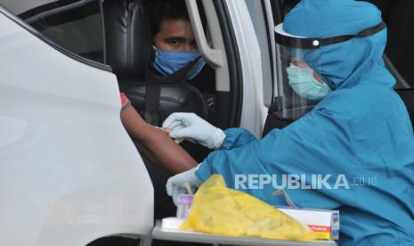 Petugas kesehatan berpakaian pelindung diri mengambil sampel darah untuk tes diagnostik cepat atau rapid test pada drive thru test COVID 19 di parkiran Rumah Sakit Siloam Sriwijaya, Palembang, Sumatera Selatan, Senin (4/5/2020). Test COVID-19 Mandiri berupa rapid test atau swab test tersebut menurut pihak rumah sakit cukup diminati banyak warga