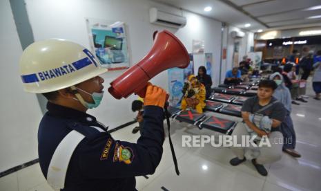 Petugas memberikan pengumuman kepada calon penumpang di Stasiun Pasar Senen, Jakarta, Senin (23/3/2020).  Mulai Senin (23/3), PT Kereta Api Indonesia (KAI) Daerah Operasi (Daop) 1 Jakarta membatalkan 19 perjalanan keberangkatan Kereta Api (KA) jarak jauh dari Stasiun Gambir dan Pasar Senen sebagai pencegahan penyebaran virus Corona (COVID-19).