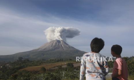  Pemuda Indonesia menyaksikan Gunung Sinabung memuntahkan material vulkanik saat terjadi letusan di Karo, Sumatera Utara, Indonesia, Kamis, 11 Maret 2021.