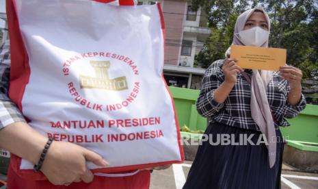 Sejumlah pedagang menunjukkan paket bahan pokok dan Bantuan Tunai untuk Pedagang Kaki Lima dan Warung (BT-PKLW) di Pasar Sederhana, Sukajadi, Kota Bandung, Senin (17/1/2022). Dalam kunjungan tersebut Presiden RI Joko Widodo membagikan 2.000 paket sembako serta menyalurkan Bantuan Tunai untuk Pedagang Kaki Lima dan Warung (BT-PKLW) sebesar Rp1,2 juta kepada sedikitnya 100 pedagang di pasar tersebut. 