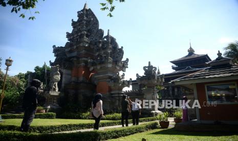 Petugas mengukur suhu tubuh wisatwan ketika hendak memasuki museum Indonesia saat berlangsungnya simulasi normal baru di TMII, Jakarta, Kamis (4/5). Pengelola Taman Mini Indonesia Indah (TMII) siap membuka kembali seluruh wahana wisata pada Sabtu (20/6).