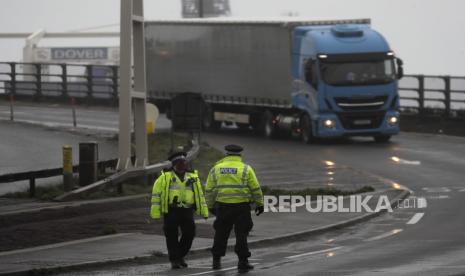  Petugas polisi mengarahkan lalu lintas di pintu masuk terminal feri yang ditutup di Dover, Inggris, Senin, 21 Desember 2020, setelah Pelabuhan Dover ditutup dan akses ke terminal Eurotunnel ditangguhkan menyusul pengumuman pemerintah Prancis. Prancis melarang semua perjalanan dari Inggris selama 48 jam mulai Minggu tengah malam, termasuk truk yang membawa barang melalui terowongan di bawah Selat Inggris atau dari pelabuhan Dover di pantai selatan Inggris.