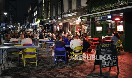 Sejumlah orang menikmati makan dan minum di sebuah restoran di Soho, London, Selasa (22/9). Perdana Menteri Inggris Boris Johnson mengumumkan bahwa tempat pub dan restoran akan tutup pada pukul 10 malam hal ini akibat karena lonjakan kasus Covid-19 di seluruh Inggris Raya. AP Photo/Alberto Pezzali