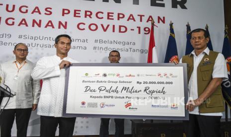 Pimpinan Grup Bakrie Anindya Bakrie (kedua kiri) menyerahkan bantuan kepada Kepala Badan Nasional Penanggulangan Bencana (BNPB) Doni Monardo (kanan) disaksikan Staf Khusus Menteri BUMN Arya Mahendra Sinulingga (kedua kanan) dan Ketua Umum KADIN Indonesia Rosan Roeslani (kiri) saat penyerahan bantuan di Graha BNPB, Jakarta, Jumat (27/3/2020). Grup Bakrie menyerahkan bantuan untuk penanganan penyebaran virus COVID-19 berupa uang sebesar Rp20 Miliar yang diserahkan kepada Gugus Tugas Percepatan Penanganan COVID-19 BNPB