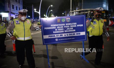 Petugas Kepolisian menutup akses jalan di kawasan Bulungan saat jam pembatasan kegiatan masyarakat di Jakarta, Selasa (22/6). Polda Metro Jaya melakukan penutupan 10 ruas jalan di Jakarta pada pukul 21.00 hingga 04.00 WIB mulai hari ini Senin 21 Juni 2021 dalam rangka pembatasan kegiatan masyarakat mengingat kasus positif Covid-19 harian di Jakarta mengalami peningkatan. Republika/Thoudy Badai