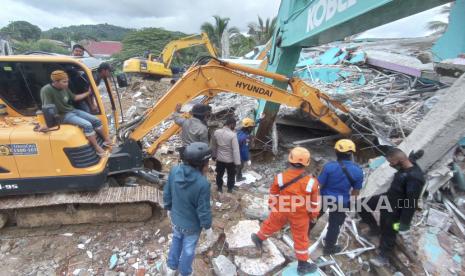  Tim penyelamat Indonesia mencari korban di bawah reruntuhan bangunan yang runtuh setelah gempa berkekuatan 6,2 di Mamuju, Sulawesi Barat, Indonesia, 15 Januari 2021. Sedikitnya tujuh orang tewas dan ratusan lainnya luka-luka.