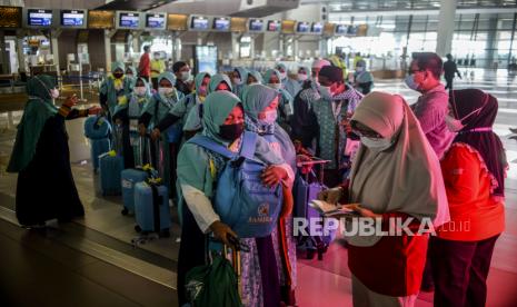 Petugas mengecek dokumen calon jamaah umrah di Terminal 3 Bandara Internasional Soekarno-Hatta, Tangerang, Banten, Sabtu (8/1). Sebanyak 419 orang berangkat melaksanakan ibadah umrah setelah beberapa tahun terakhir Indonesia tidak mengirimkan jamaah akibat pandemi Covid-19. 3.900 Jamaah ke Tanah Suci Tunaikan Umroh Selama Pandemi