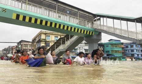 Warga setempat mengarungi jalan yang terendam banjir di Bago, sekitar 80 kilometer (50 mil) timur laut Yangon, Myanmar, Myanmar, Selasa, (10/10/2023). Banjir yang dipicu oleh hujan lebat di wilayah selatan Myanmar telah menyebabkan lebih dari 10.000 orang mengungsi dan mengganggu lalu lintas di jalur kereta api yang menghubungkan kota-kota terbesar di negara itu, kata para pejabat dan media pemerintah pada hari Senin.